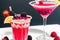 glass of tasty raspberry cocktail on light background