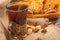 A glass of tea in a vintage Cup holder and cookies in a wicker basket on a background of rough homespun fabric. Close up