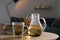 Glass teapot and cup of hot tea on wooden table in living room. Cozy home atmosphere