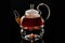 Glass teapot on a glass stand heated by a candle on a black background, black tea in a glass teapot