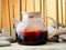 Glass teapot with hot red berry tea karkade, close-up. Tea on the background of a bamboo grove and stones. Traditional Chinese tea