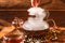 The glass teapot in which the tea is poured stands on a wooden background. a woman`s hand removes the lid from the kettle. steam