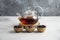 A glass teapot with wooden bowls of loose teas