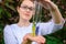 Glass test tubes with flower samples, close-up. Female hands holding flasks, blurred background. Study of plants, medicinal herbs