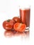 The glass of tomato juice and tomatoes