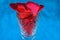 Glass transparent goblet full of red hearts on blue background