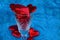 Glass transparent goblet full of red hearts on blue background