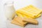 Glass transparent pitcher with milk, yellow napkin and wafers