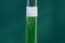 Glass tube with green liquid and white foam