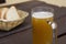 Glass of unfiltered beer and bread on wooden table