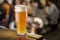 Glass of unfiltered beer stands on a table in a pub