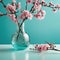 Glass vase with pink blossoms flowers twigs on glass table near empty, blank turquoise wall background with copy space