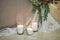 Glass vases with white burning  candles stand on the floor