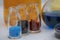 Glass vials with colored medicine liquid with capillaries. Red, yellow and blue solutions in glass vial in chemistry laboratory
