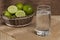 Glass with water and basket with lemons to prepare a drink