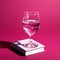 Glass Of Water On Book On Pink Background Concept