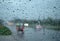 Glass water droplets. Blurred background. Road with cars. Concept. Rainy season driving on bad weather days. poor visibility feels