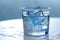 Glass with water and ice cubes on a blue background. A refreshing and chilling drink. Generative AI