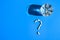 Glass of water and pills in shape of question mark on blue background. Hard light and shadows. Vitamins and prebiotics, probiotics