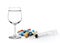 Glass of water syringe and colorful pill and capsules