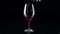 Glass in which the sommelier pouring red wine, black, silhouette, slowmotion, closeup