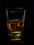 Glass of whiskey with ice on a black background with reflection