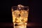 glass of whiskey with ice cubes on dark background and wood table, relax with whisky concept on the warm atmosphere