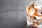 Glass of whiskey with ice cubes on grey table.