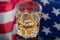 Glass of whiskey on mirror background with American flag reflected in it. Independence Day Drink