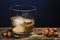 Glass of whiskey, scotch tape, on wooden background. Almonds and hazelnuts are nearby