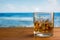 Glass of Whisky With Ice on a Wooden Table Against The Sea