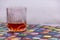 A GLASS OF WHISKY SITTING COLORFUL TABLE