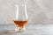 Glass of whisky spirit brandy on gray concrete background