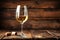 a glass of white wine on an antique wooden table