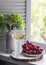 Glass of white wine and a plate of red grapes on the window - a delicious aperitif, snack