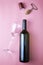 Glass wine bottle glass stopper corkscrew and shrink cap on pink background