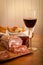 A glass of wine, bread and salami