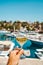 Glass of wine in hand. A glass of white wine against the backdrop of the Mediterranean sea and the port with yachts in a