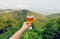 Glass of wine in hand of tourist in natural landscape of green Alazani Valley, Georgia. Homemade beverage