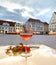 Glass of wine  red rowan branch  and on  table at street cafe in town hall square in rainy  Tallinn old town medieval city houses