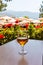 glass of wine on wooden table in the background of beach umbrellas