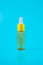 glass yellow bottle with pipette with essential oil on a blue background top view. Aromatic cosmetic product for skin hair care