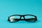 Glasses in black plastic frames on a blue background