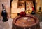 Glasses and bottles of red and white wine on old barrel in wine cellar