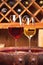 Glasses and bottles of red and white wine on old barrel in wine cellar