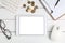 Glasses, calculator,coins and tablet on white neat desk