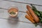 Glasses of carrot juice and fresh carrots on wooden background