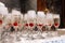 Glasses with champagne with cherry and steam from dry ice on marble table at the event. Bartender serves one glass of