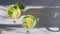 Glasses with chilled lemon mojito with green mint leaves and pieces of sour yellow lemon on a gray background. Top view