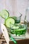 Glasses with detox cucumber water with lime and mint on a wooden tray, pitcher,summer or spring